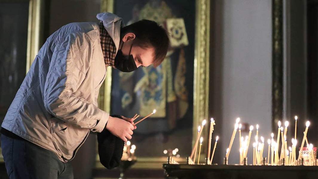 Парень ставит свечи