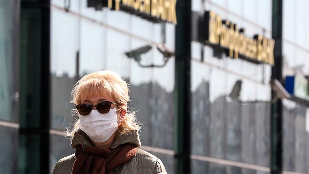 Женщина в медицинской маске у офиса Райффайзенбанка на Ленинградском шоссе