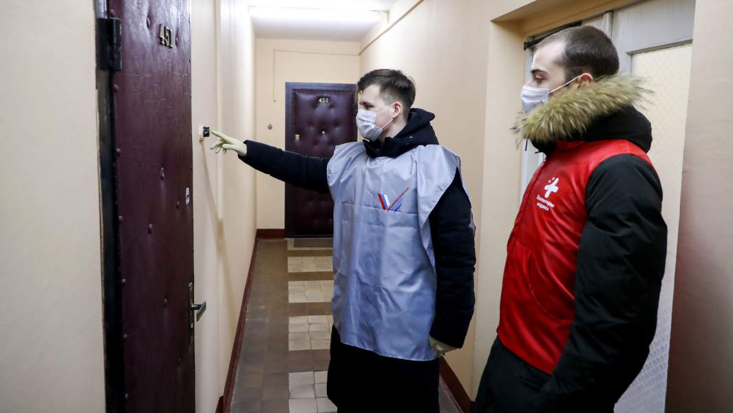 Волонтеры Общероссийского народного фронта (ОНФ) у квартиры жилого дома во время доставки продуктов пожилым людям, которые вынуждены оставаться дома в условиях распространения коронавируса