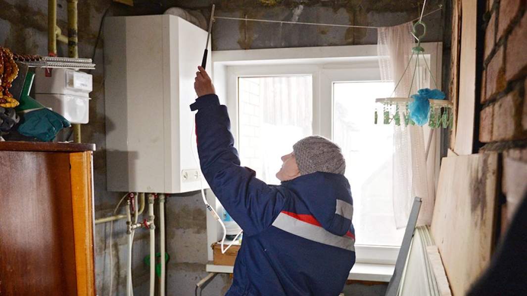 Сотрудник газовой службы проверяет исправность газового котла