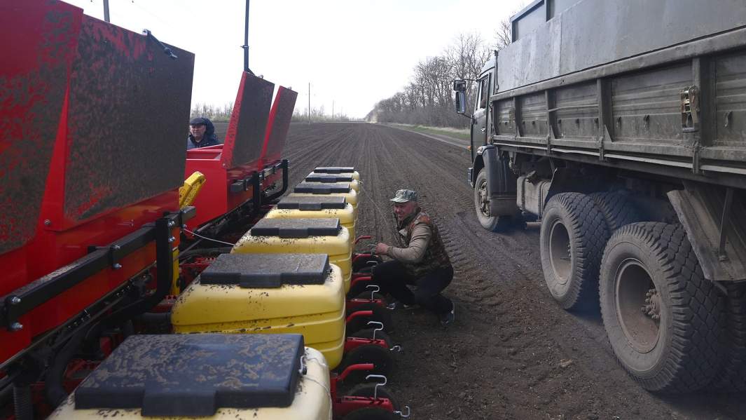 Загрузка семян подсолнечника в отсеки пневматической сеялки перед посевом на полях Ростовской области