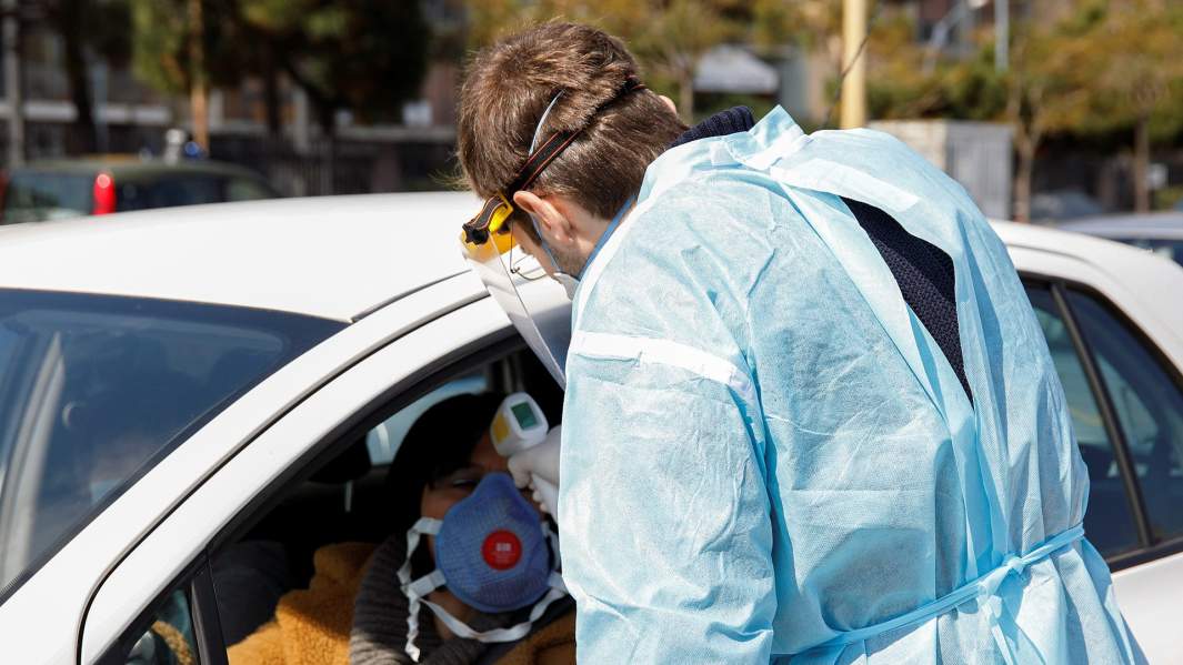 медицинский работник проверяет температуру водителя