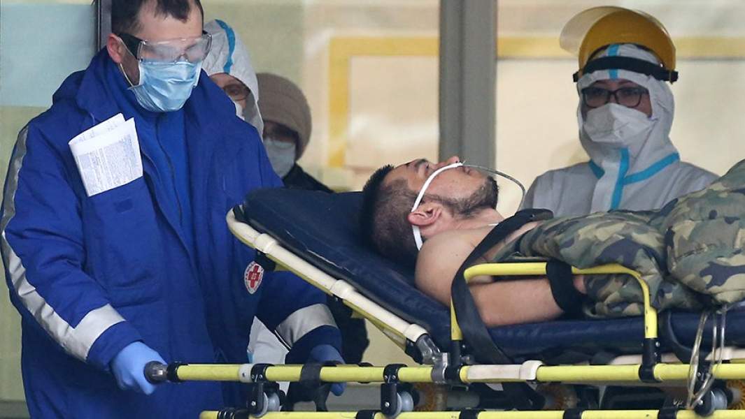 Сотрудники скорой медицинской помощи и пациент у приемного отделения Покровской больницы в Санкт-Петербурге, которая принимает пациентов с коронавирусной инфекцией COVID-19