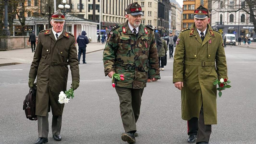 Сторонники латышского легиона «Ваффен-СС» несут цветы к памятнику Свободы в Риге по случаю дня памяти латышского легиона «Ваффен-СС», который отмечается в Латвии 16 марта