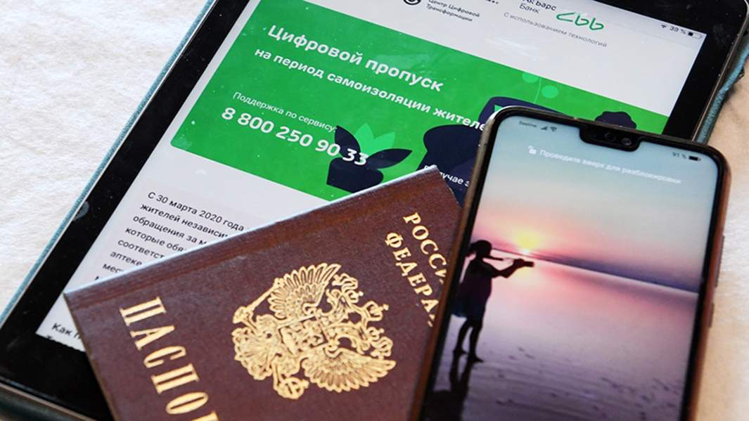 Паспорт, планшет и смартфон, позволяющие получить цифровой пропуск через смс для выхода из дома в режиме самоизоляции