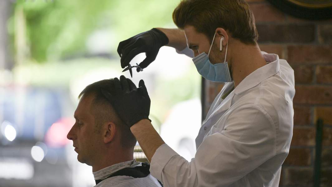 Парикмахер стрижет клиента 