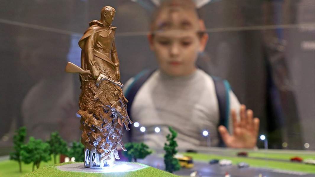 Ребенок у макета строящегося мемориального комплекса в память обо всех солдатах Великой Отечественной войны «Ржевский мемориал» на выставке «Память поколений. Великая Отечественная война в изобразительном искусстве» в музейно-выставочном объединении «Манеж»