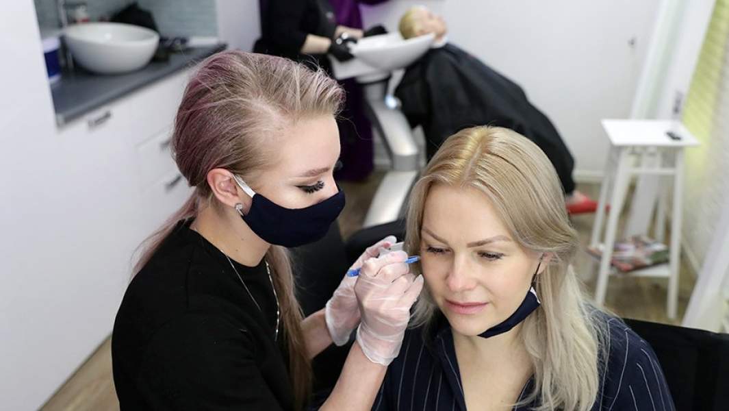 Россия. Новосибирск. Сотрудники в защитных масках в студии красоты