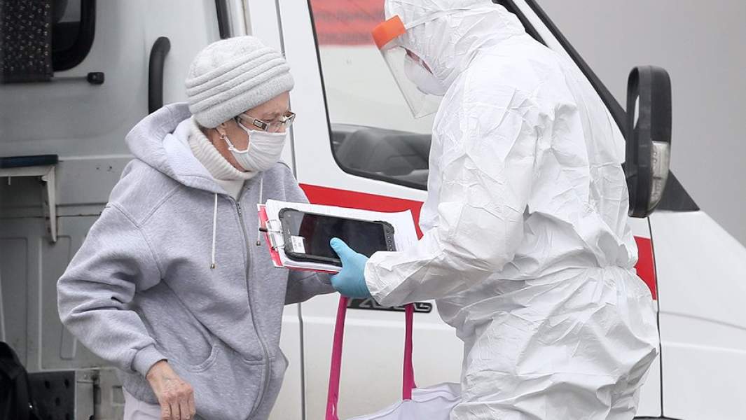 Сотрудник станции скорой медицинской помощи и пациентка с подозрением на коронавирус COVID-19 на территории многопрофильного медицинского центра «Новомосковский»