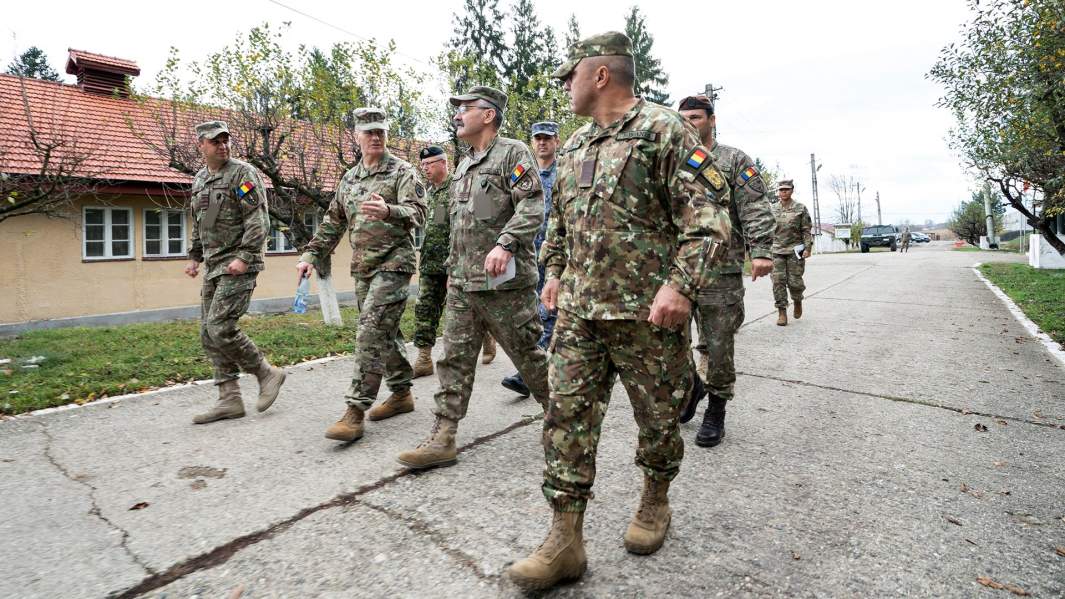 Майор Джон В. Трокселл старший военный советник председателя Объединенного комитета начальников штабов армии США, беседует с румынским полковником Джинелем Блага, заместителем командующего учебно-боевым центром сухопутных войск Гетика, во время посещения учебного центра в Чинку, Румыния