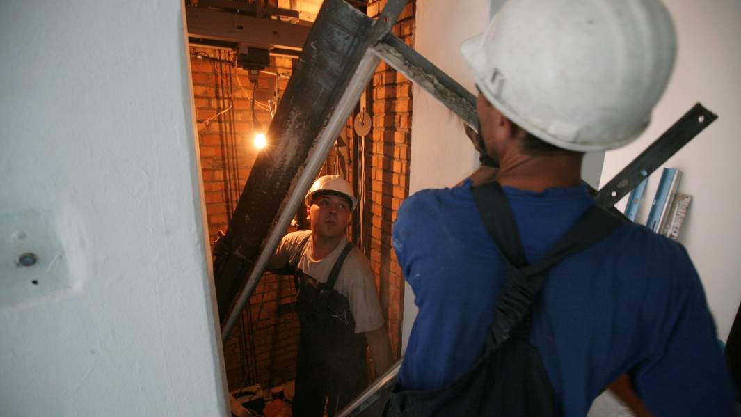 Специалисты проводят замену лифтового оборудования в многоэтажном жилом доме