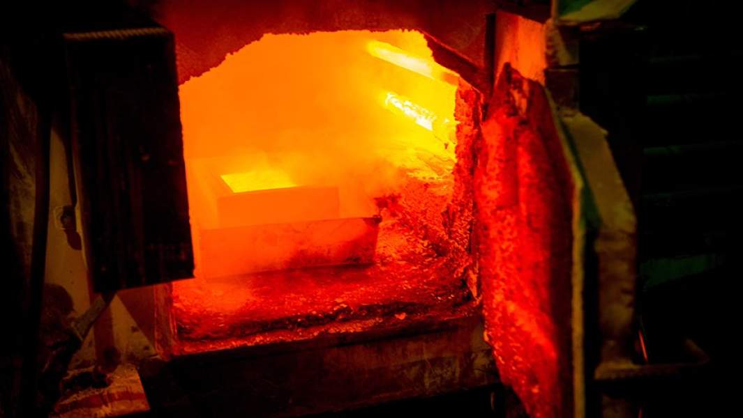 Раскаленный золотой слиток в плавильном отделении рудника