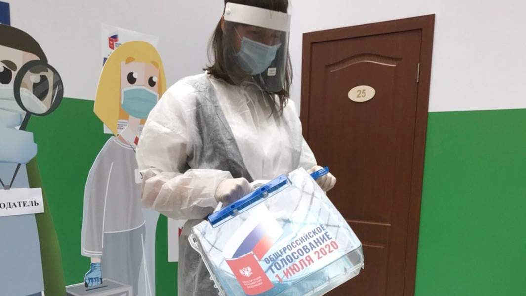 Девушка в защитном костюме члена участковой избирательной комиссии для проведения голосования по поправкам в Конституцию РФ на дому на презентации в ЦИК РФ