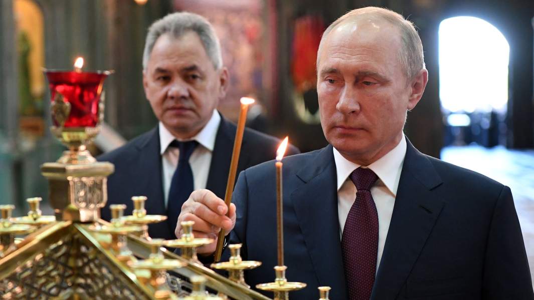 Президент РФ Владимир Путин и министр обороны РФ Сергей Шойгу (слева) во время посещения главного храма Вооружённых Сил