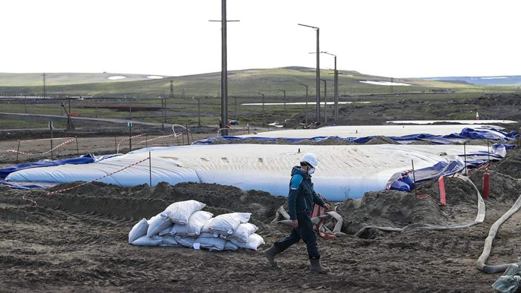 Рабочий у резервуаров для разлитого топлива у ТЭЦ-3