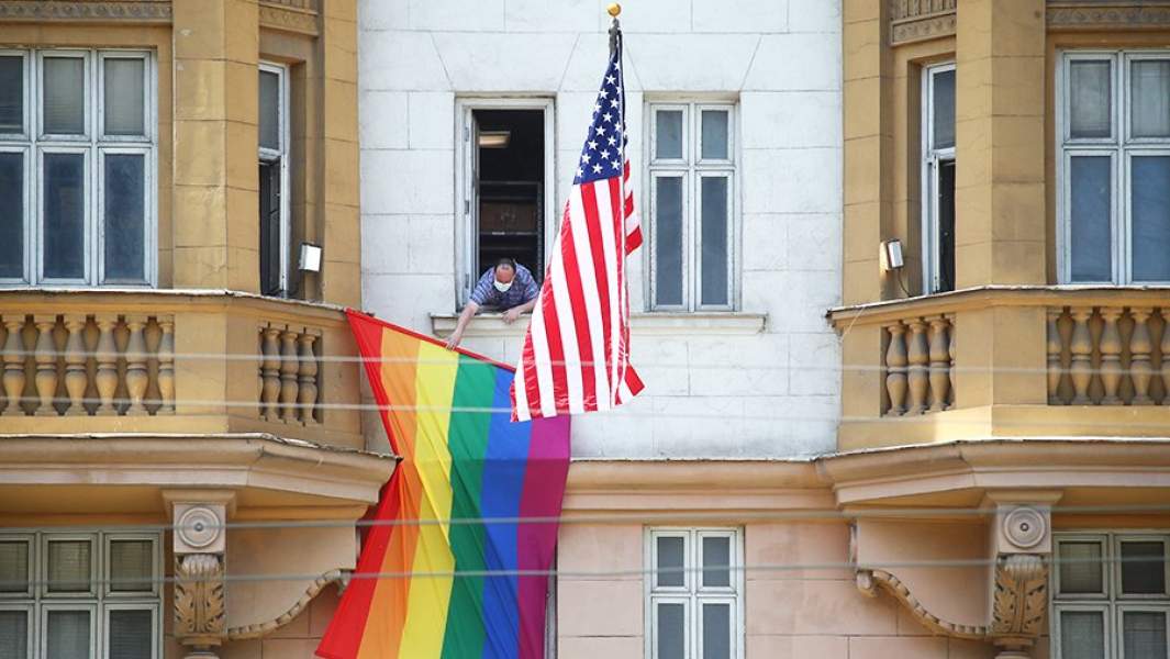Сотрудник посольства США вывешивает флаг ЛГБТ-сообщества