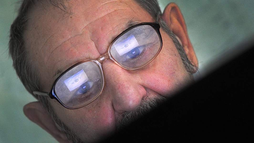 Пенсионер во время занятия в компьютерном консультационном центре для пожилых людей