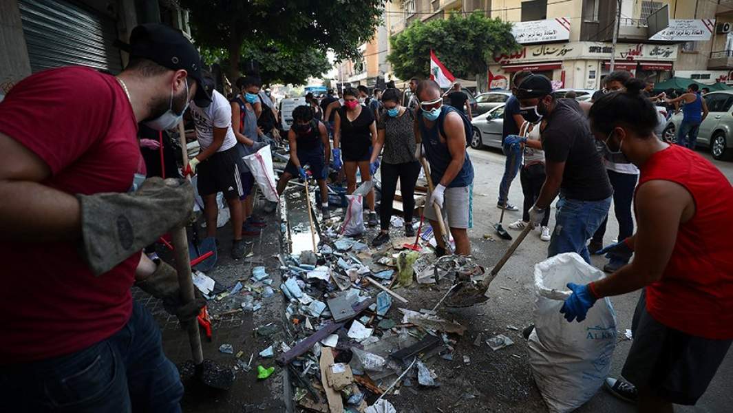 Жители убирают улицу недалеко от места взрыва 