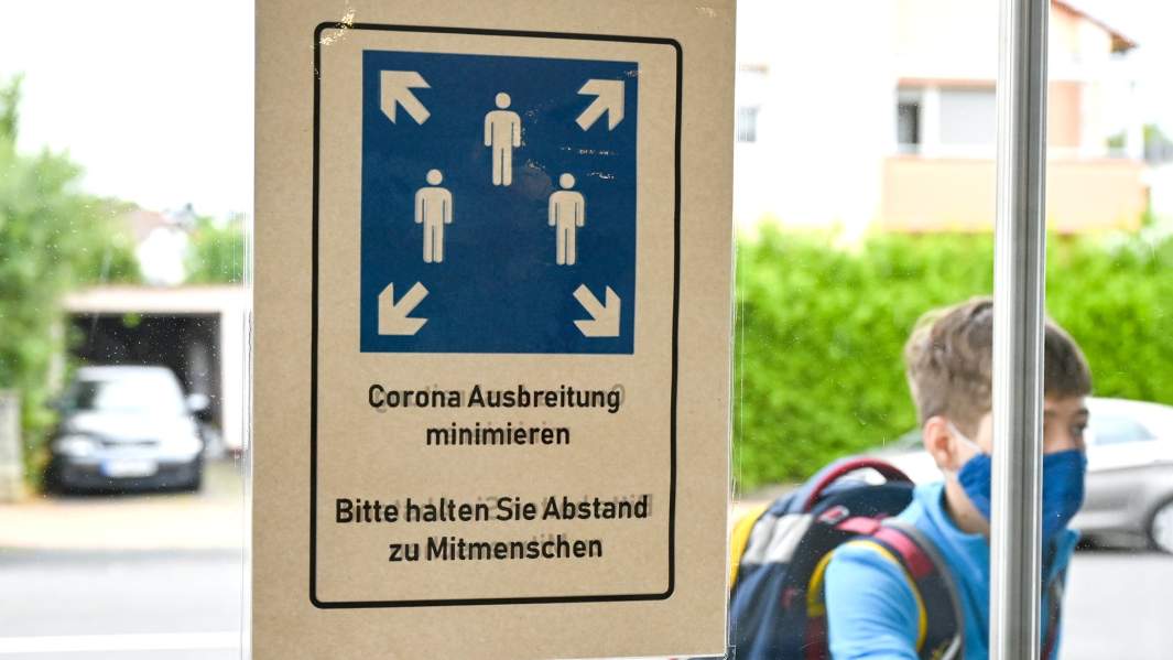 Табличка о необходимости соблюдения дистанции, на двери школы в Германии 