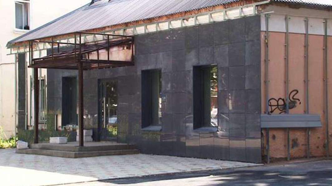 Фасад дореволюционного здания в Орле на улице Горького, 12 зашивают черными декоративными плитами.