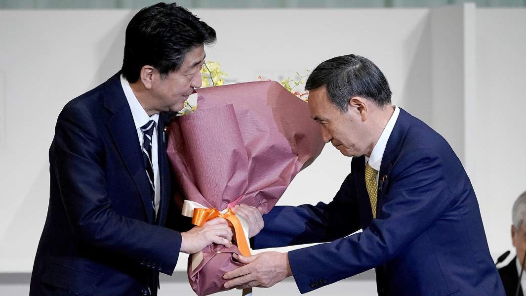Есихидэ Суга вручает цветы Синдзо Абэ