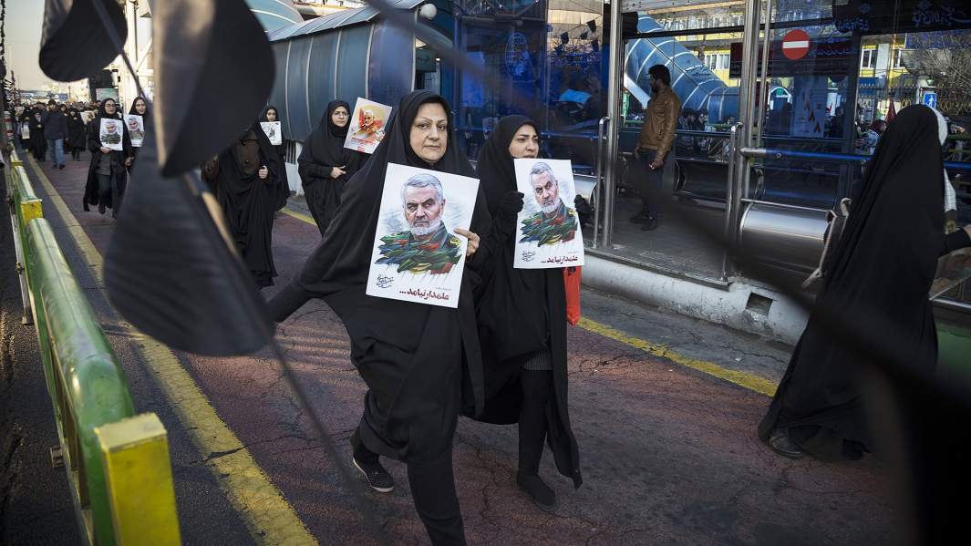 Люди с портретами Касема Сулеймани направляются на церемонию похорон