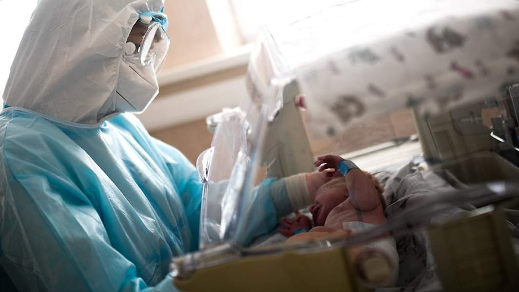 Врач осматривает ребенка в родильном отделении городской клинической больницы