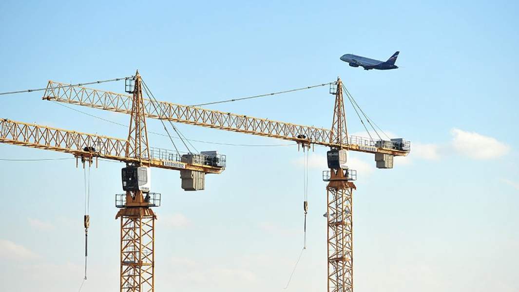 Самолет над башенными кранами
