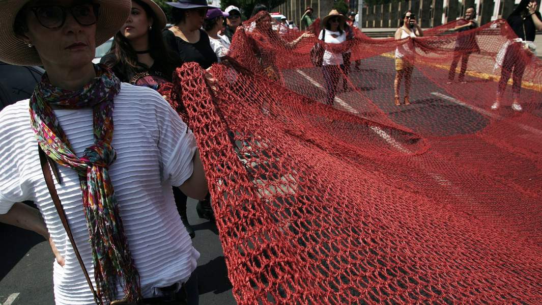Участницы протеста несут красную сетку