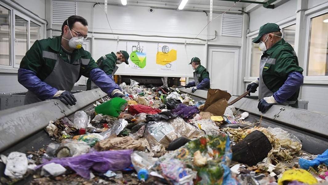 Сотрудники за работой в кабине предварительной сортировки мусора