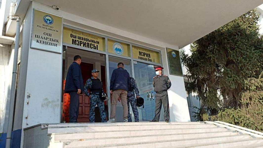 Сотрудники правоохранительных органов у входа в здание мэрии в Оше