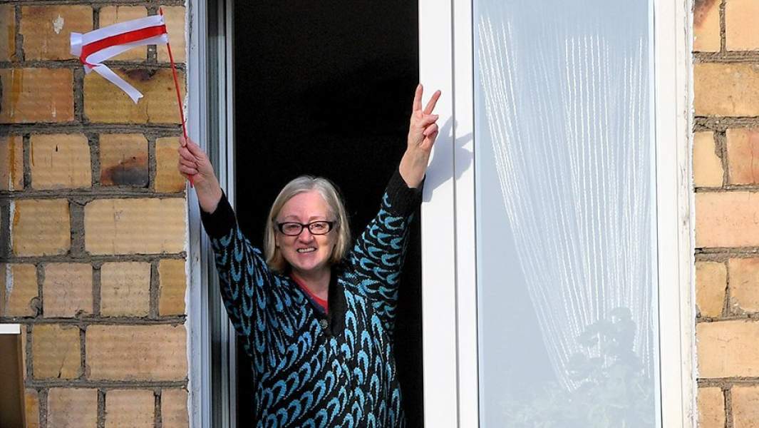 Жительница Минска в окне дома во время несанкционированной властями акции протеста «Партизанский марш»
