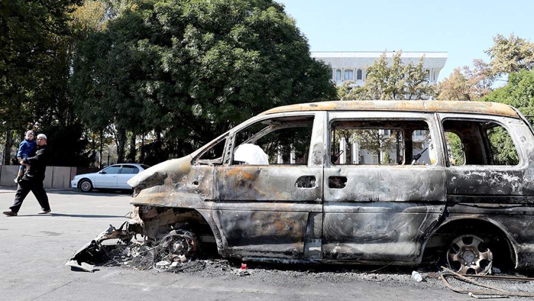Сгоревший автомобиль у здания парламента Киргизии в Бишкеке