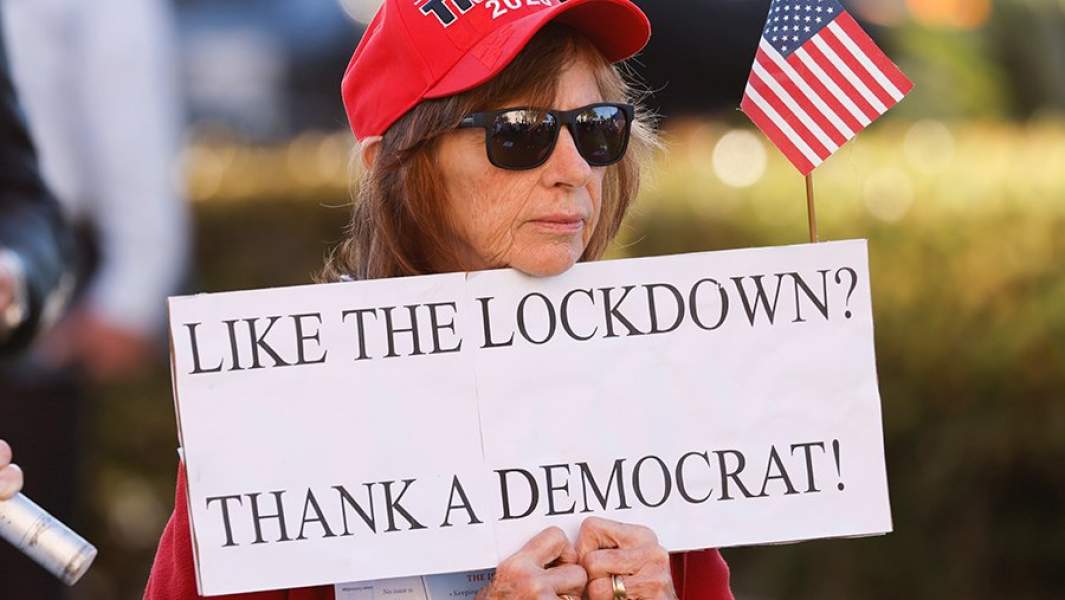 Сторонница Дональда Трампа с плакатом против введения локдауна в США на демонстрации в Сан-Диего, штат Калифорния