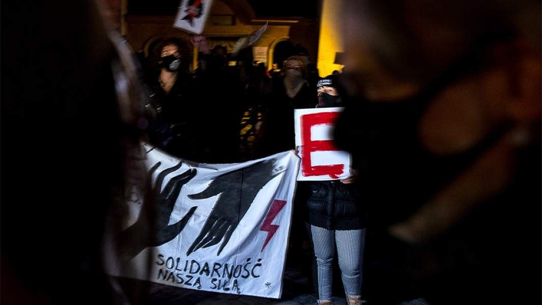 Протестующие держат плакат с надписью «Солидарность - наше оружие» во время демонстрации в Кракове, Польша, 24 ноября 2020 года