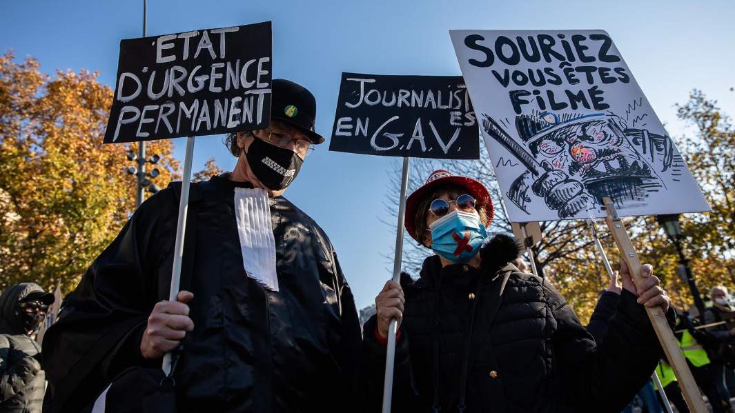 Демонстранты держат плакаты во время акции протеста против законопроекта запрещающего публиковать изображения полицейских и других сотрудников правоохранительных органов