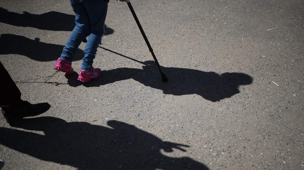 Девочка идет при помощи костылей