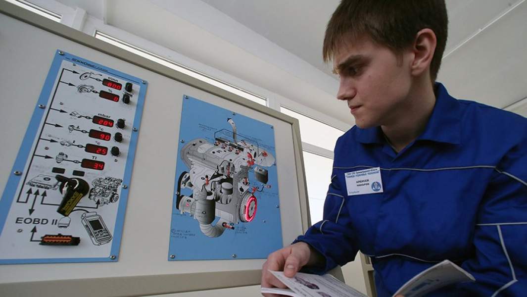 Студент изучает на стенде работу автомобильного двигателя в учебно-ресурсном центре автосборочного предприятия