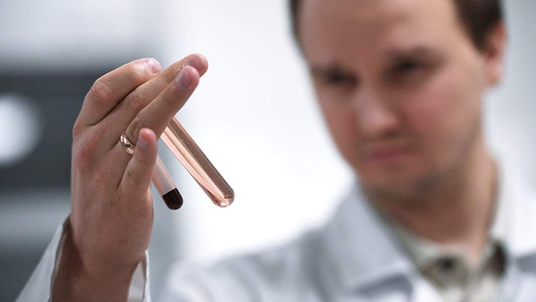 Сотрудник держит пробирки с пробами