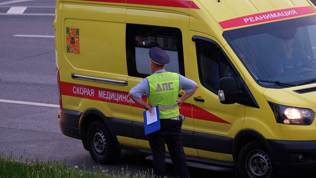 Сотрудник Дорожно-патрульной службы ГИБДД и автомобиль скорой медицинской помощи на дороге