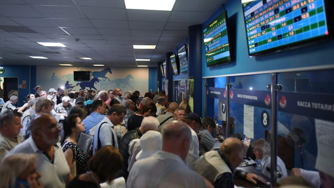 Игроки на тотализаторе ждут результатов скачек на приз президента России на Центральном московском ипподроме.