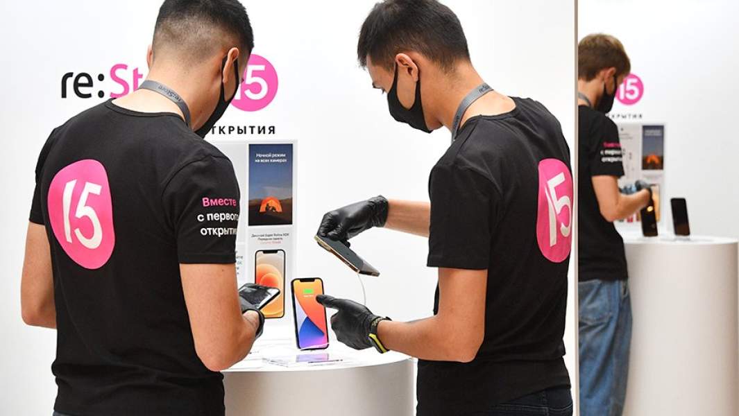Продавцы магазинав Государственном универсальном магазине в Москве, где начались продажи новых iPhone 12