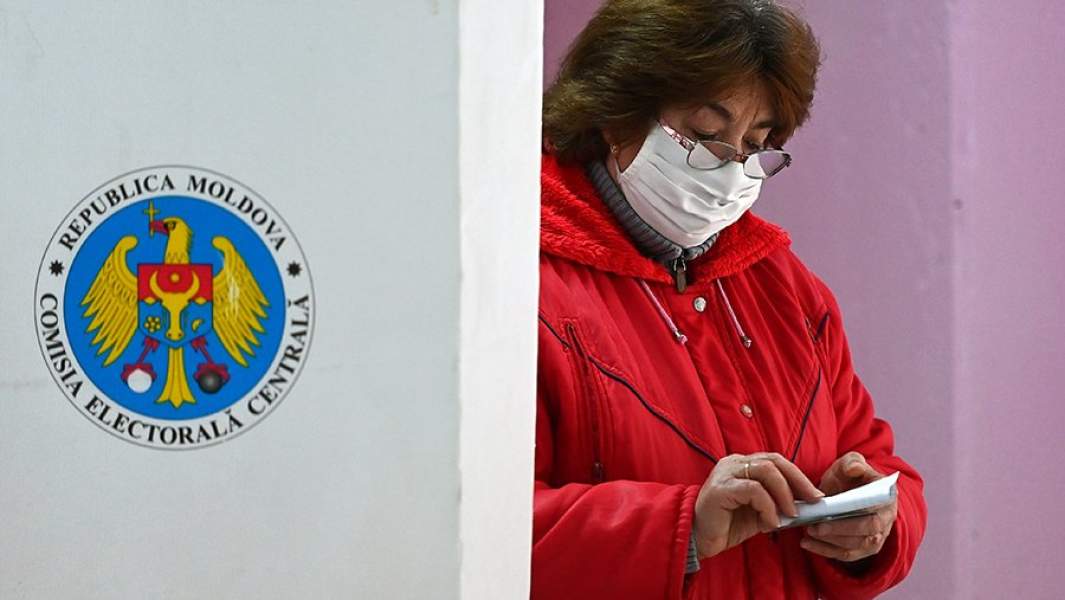 Женщина голосует во время второго тура на выборах президента Молдавии на избирательном участке в Кишиневе