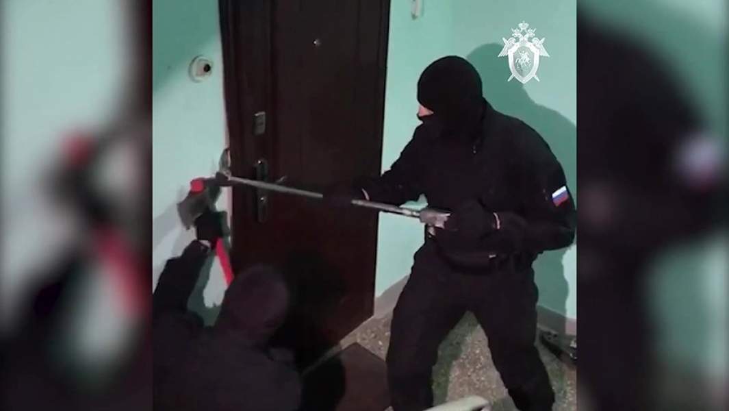 Сотрудники правоохранительных органов выламывают дверь квартиры в Москве, где действовал центр «Свидетели Иеговы» (организация признана экстремистской, деятельность запрещена на территории РФ), в рамках операции по задержанию руководителей центра
