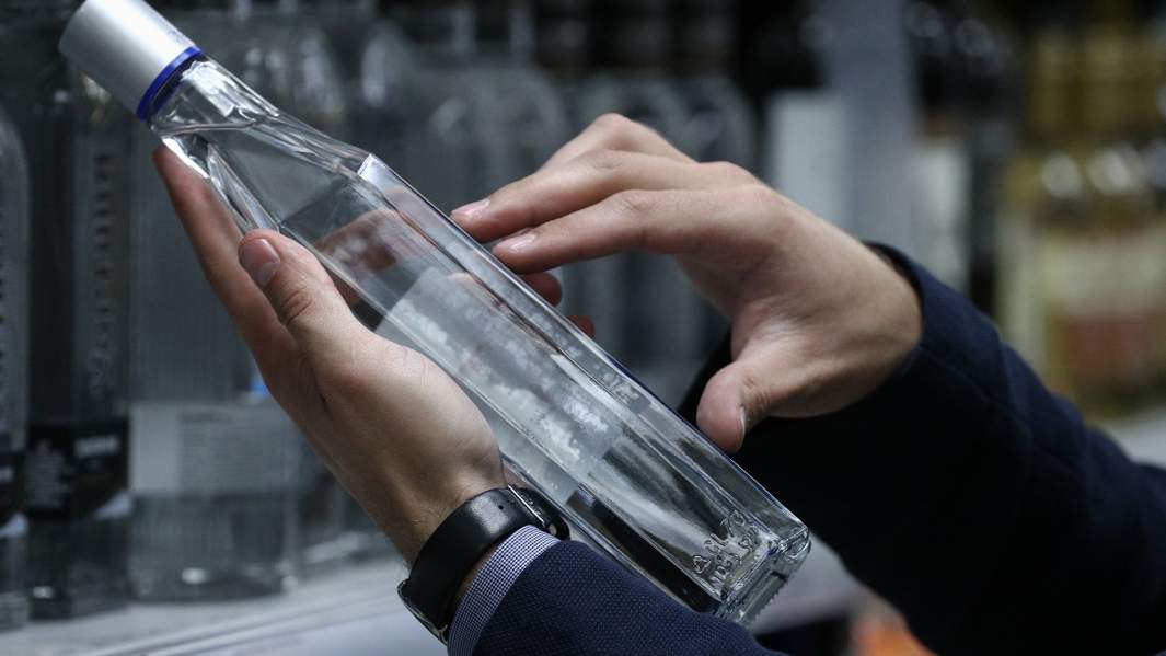 Покупатель в магазине читает этикетку бутылки