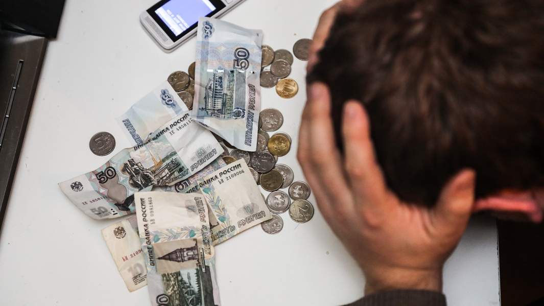 Мужчина расстроен. Рядом валяются деньги и телефон.