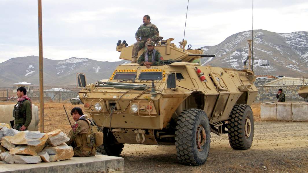 Солдаты афганской армии за пределами военного городка после взрыва заминированного автомобиля на окраине города Газни, Афганистан