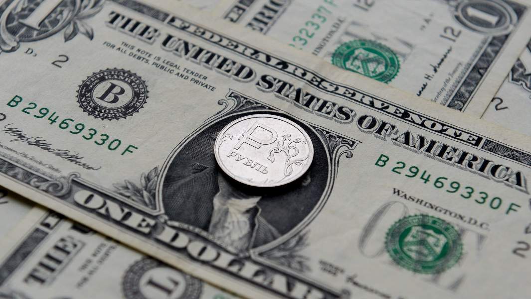 Купюры доллара и монета рубль