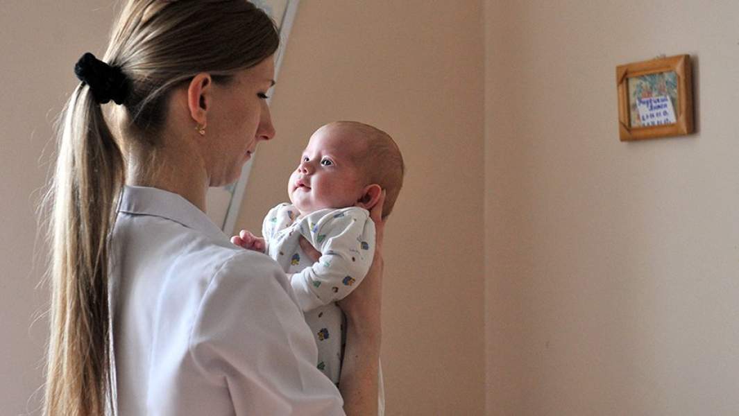 Врач держит ребенка в социальном отделении городской детской больницы