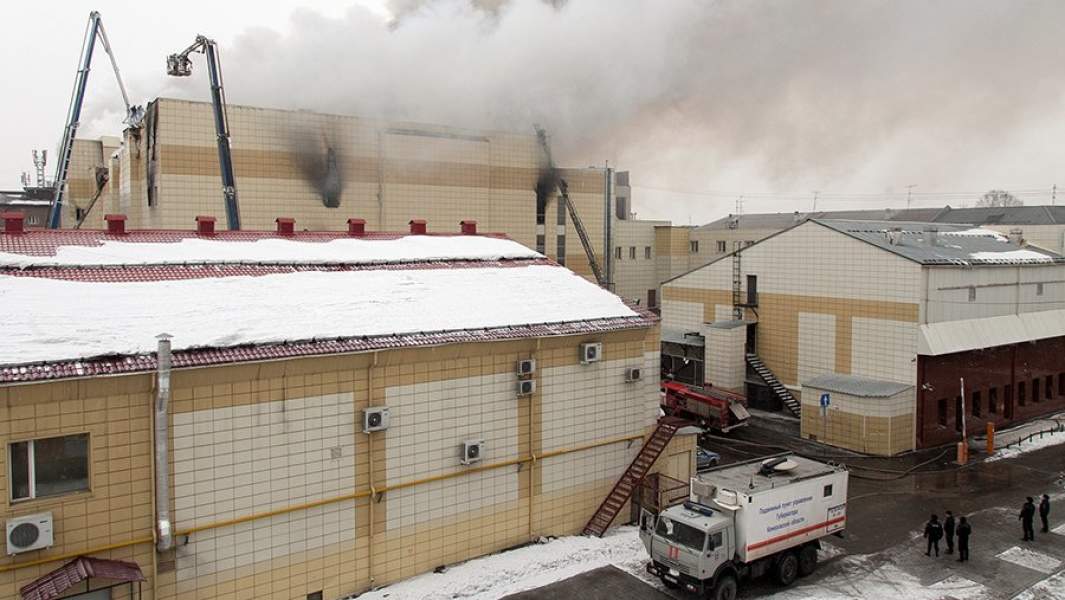 Сотрудники пожарной охраны МЧС борются с пожаром в торговом центре «Зимняя вишня» в Кемерово